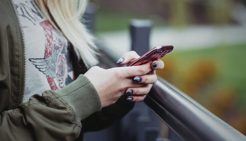 close-up of a person holding a smartphone in an outdoor setting